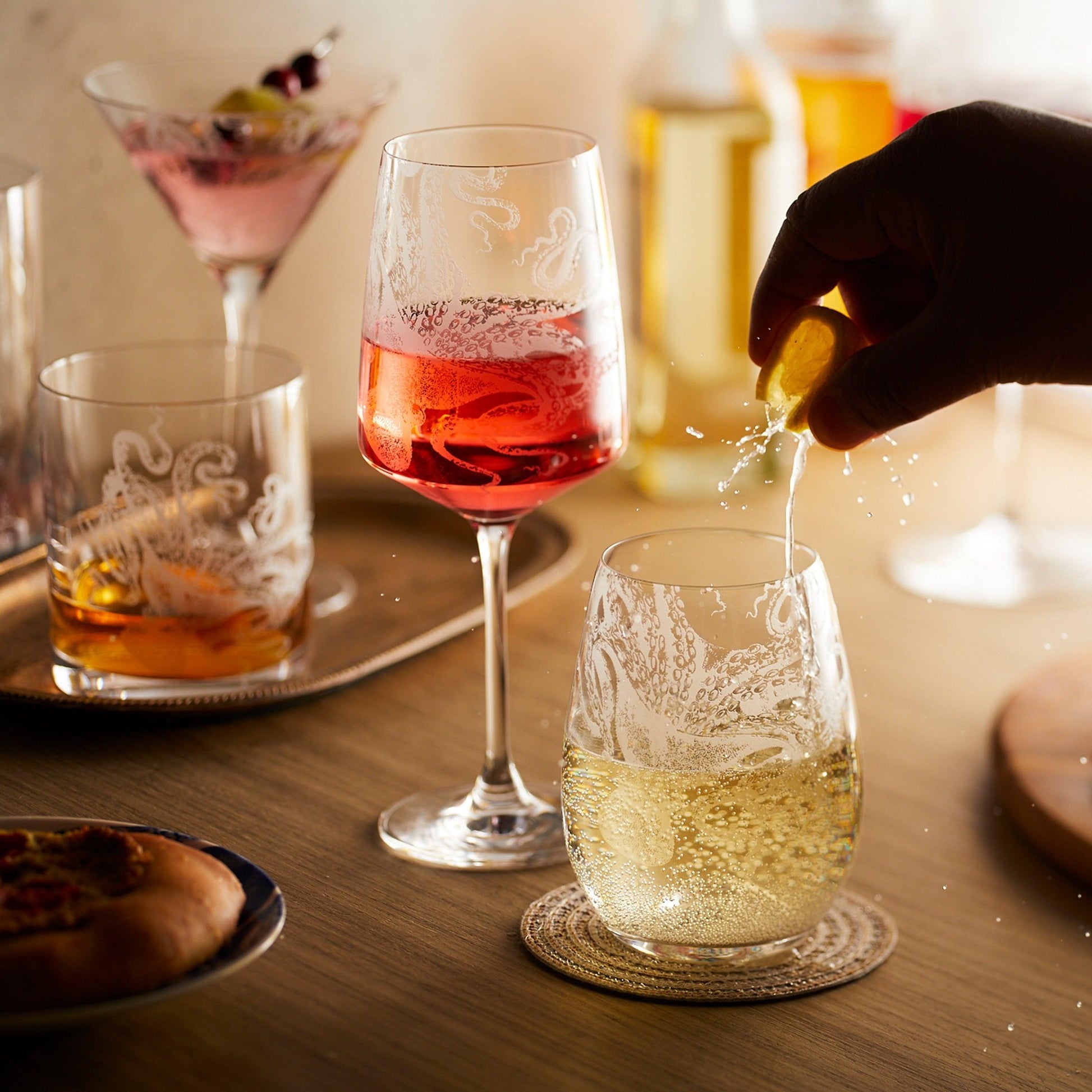 a person pouring a drink into a wine glass