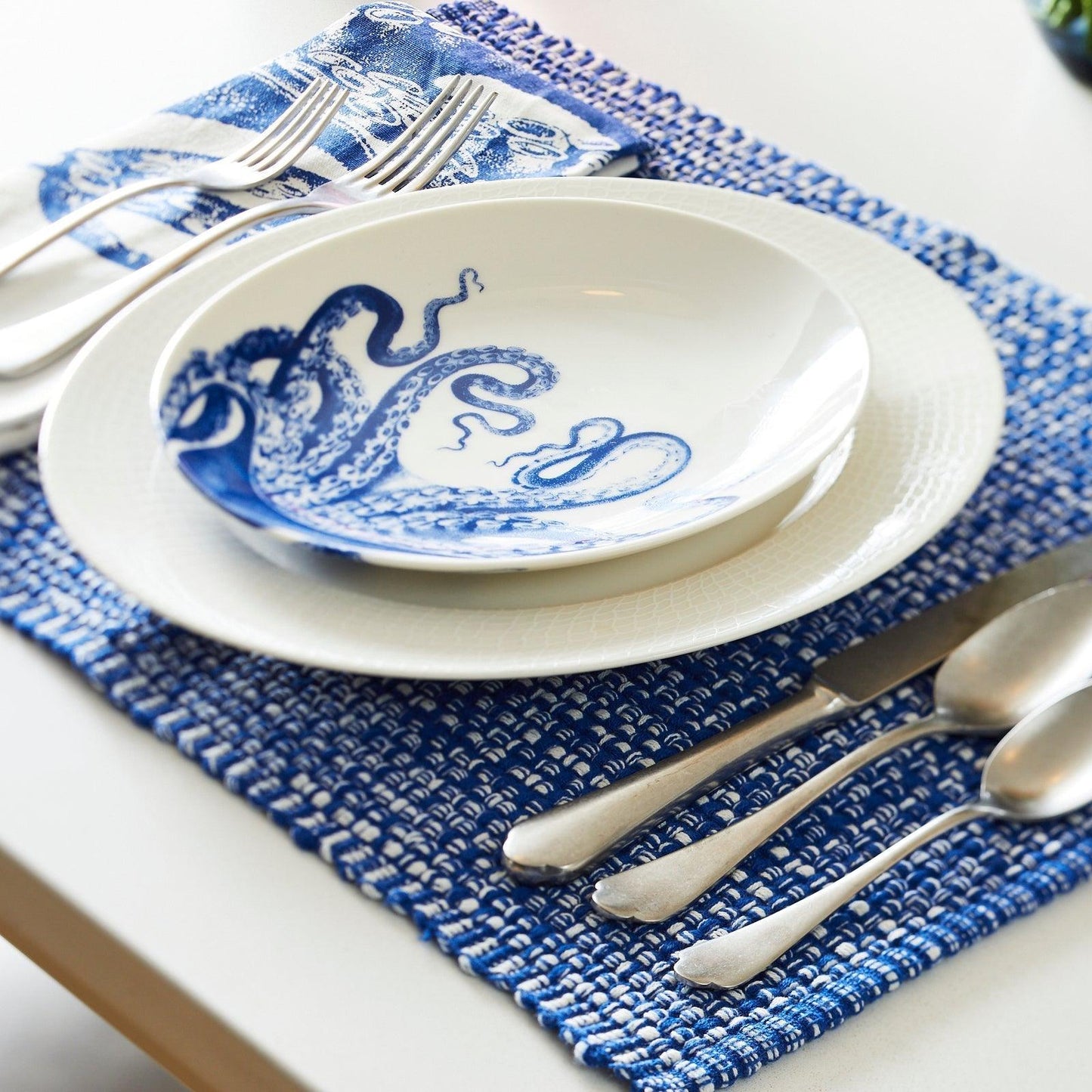 a blue and white place setting with silverware