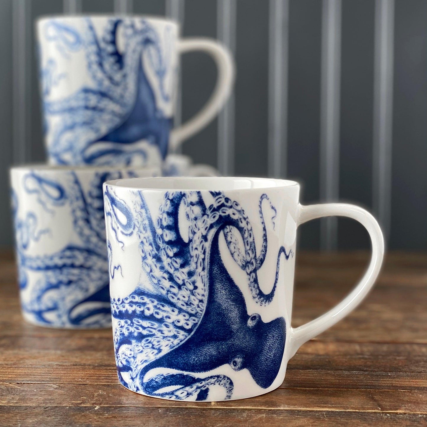 two blue and white coffee mugs sitting on a wooden table