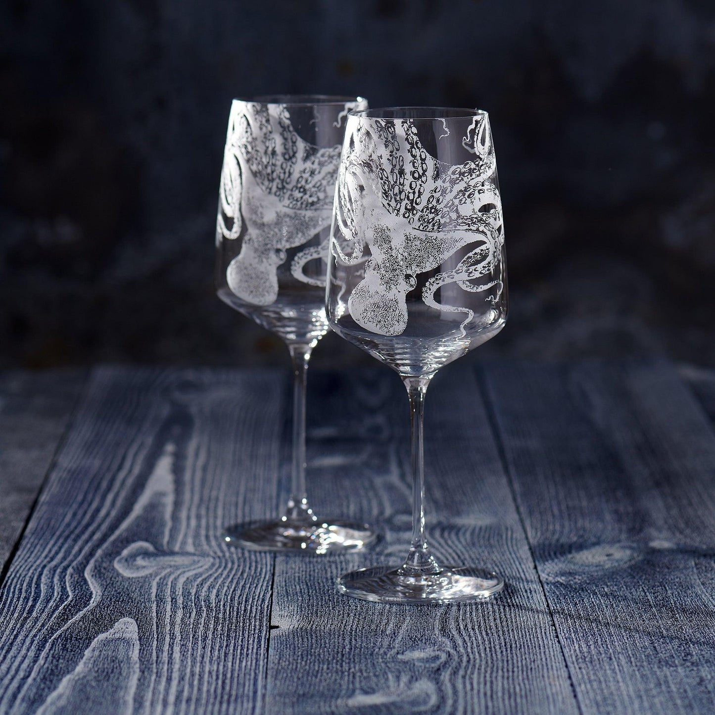 a couple of wine glasses sitting on top of a wooden table