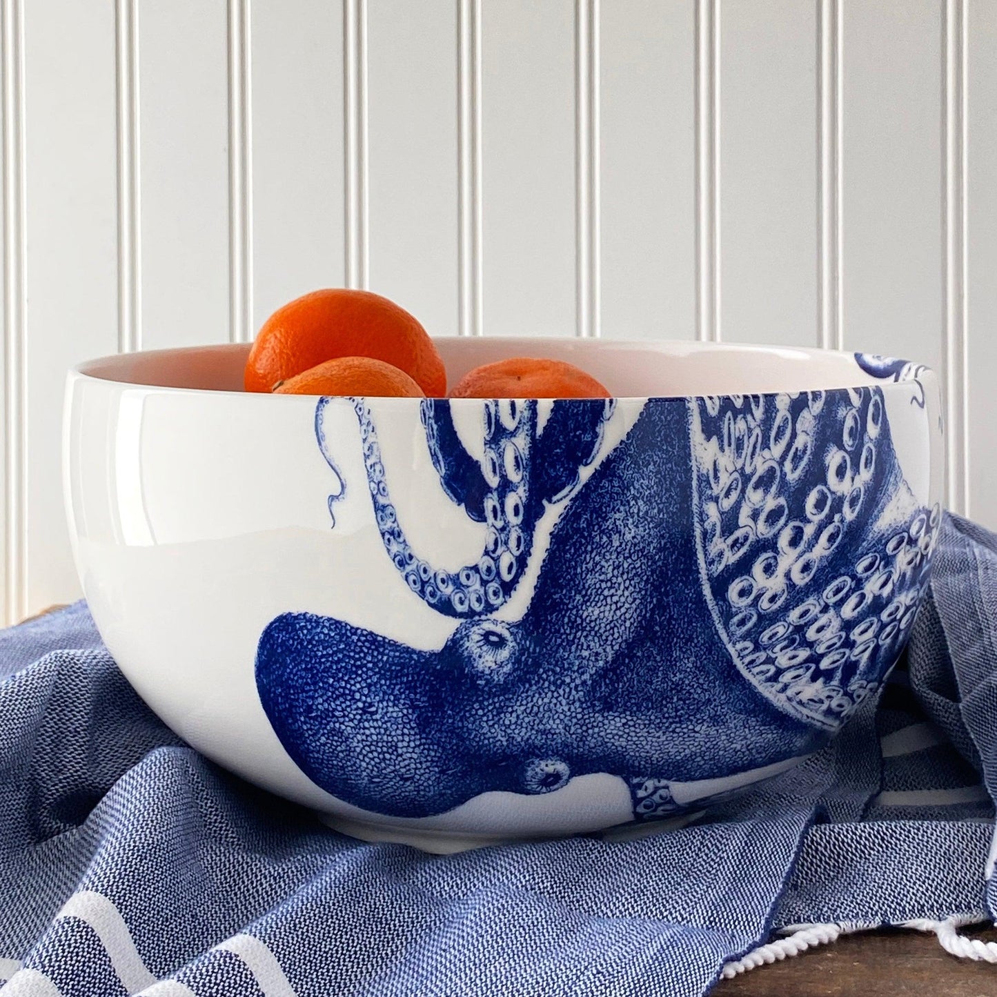 a blue and white bowl with oranges in it