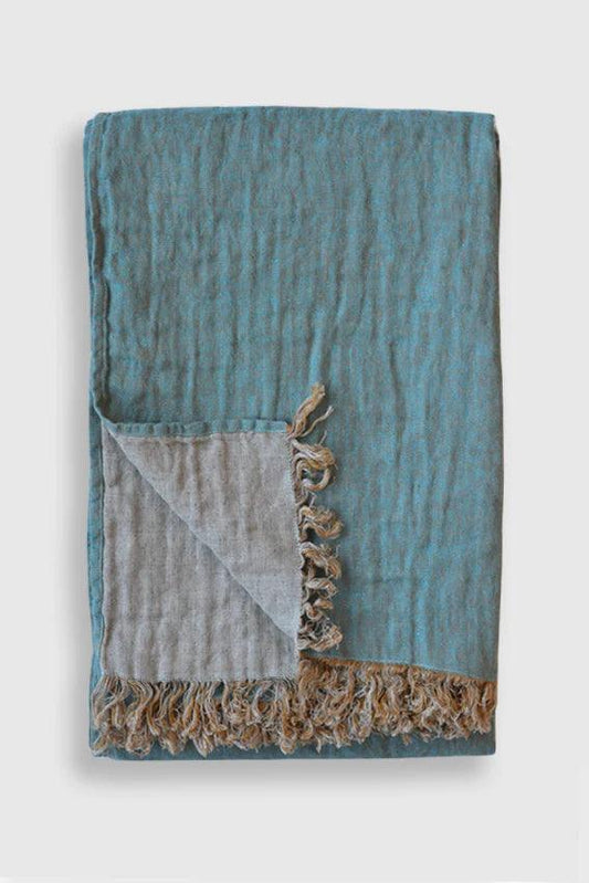 a blue and grey blanket with fringes on it
