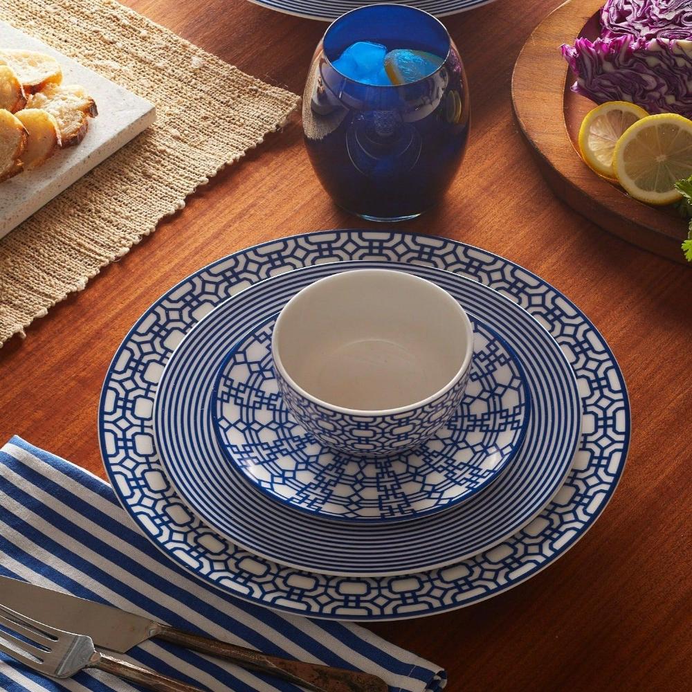 a wooden table topped with plates and bowls filled with food