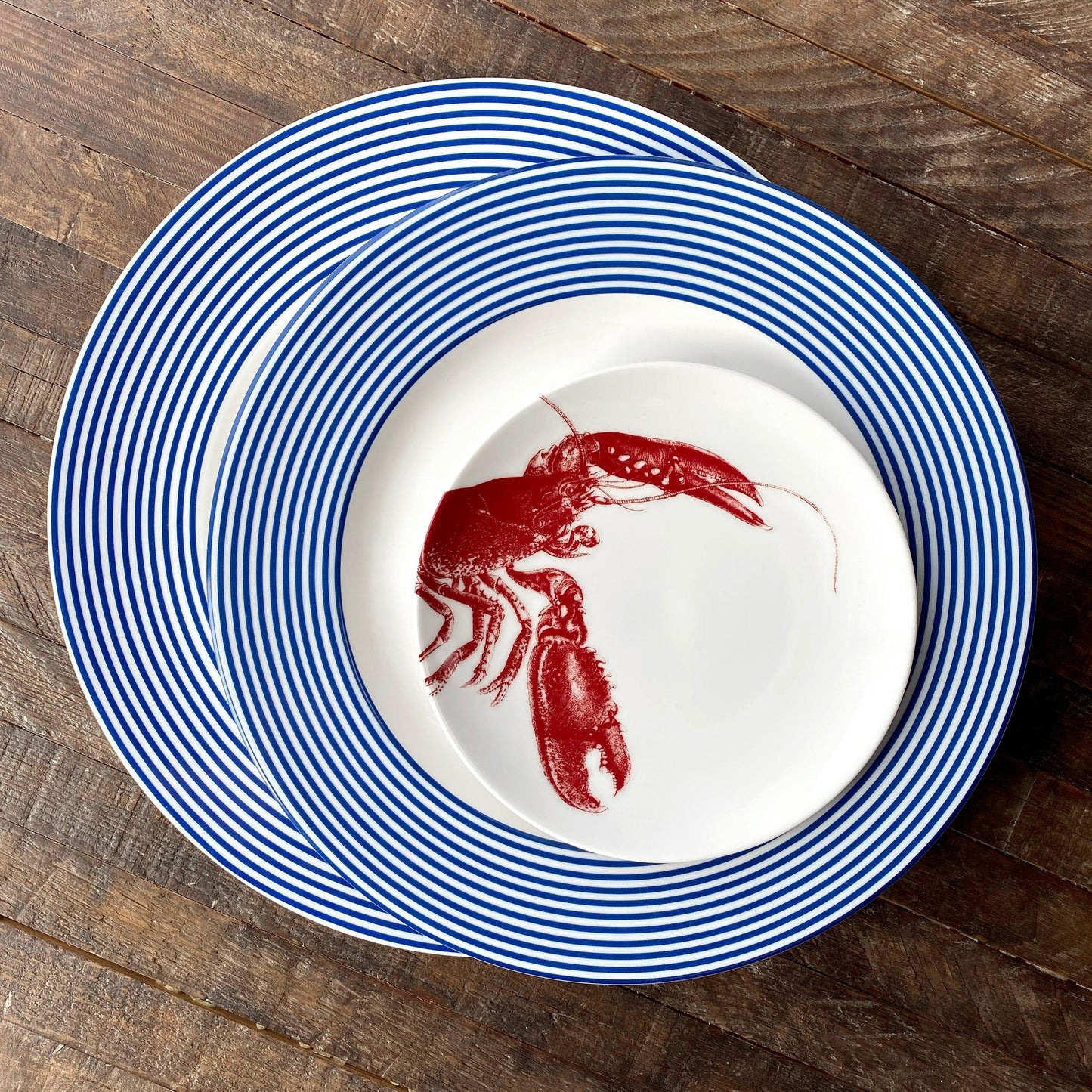 a blue and white plate with a red lobster on it