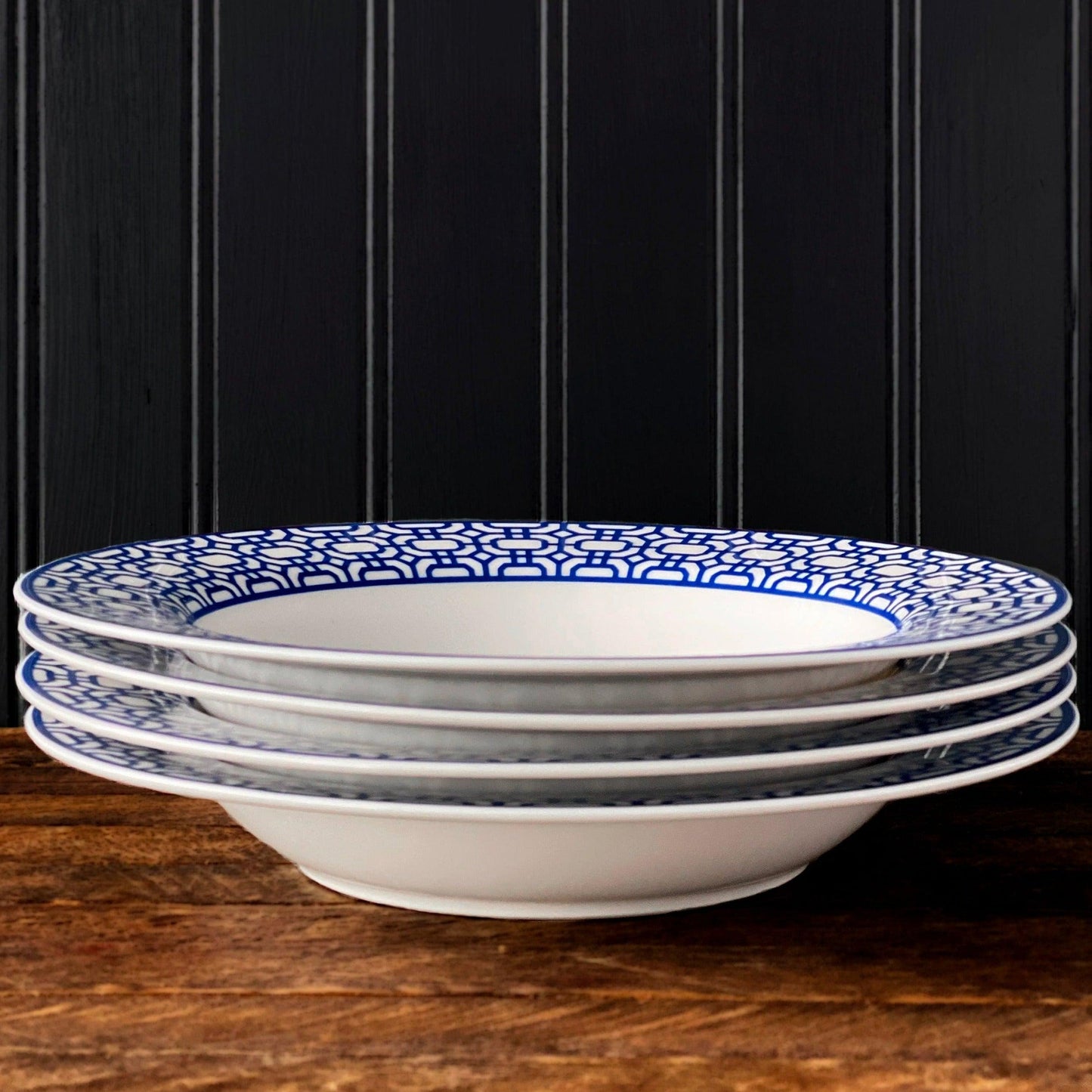 a stack of blue and white plates sitting on top of a wooden table