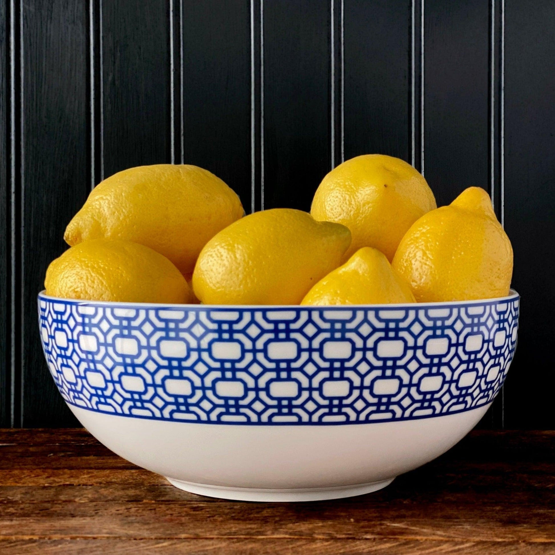 a blue and white bowl filled with lemons