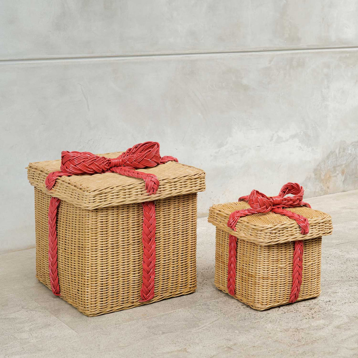 	Large and small honey-colored rattan storage gift boxes with red woven bows and matching lids