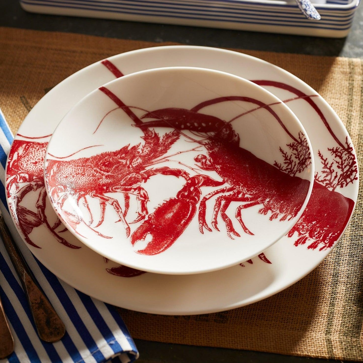 a red and white plate with a lobster on it