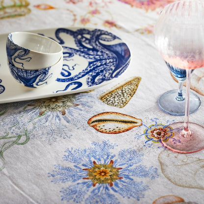 Lucy octopus snack bowl on a matching serving platter beside stemmed glasses and a colorful marine-pattern tablecloth