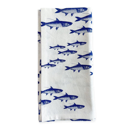 a blue and white dish towel with fish on it