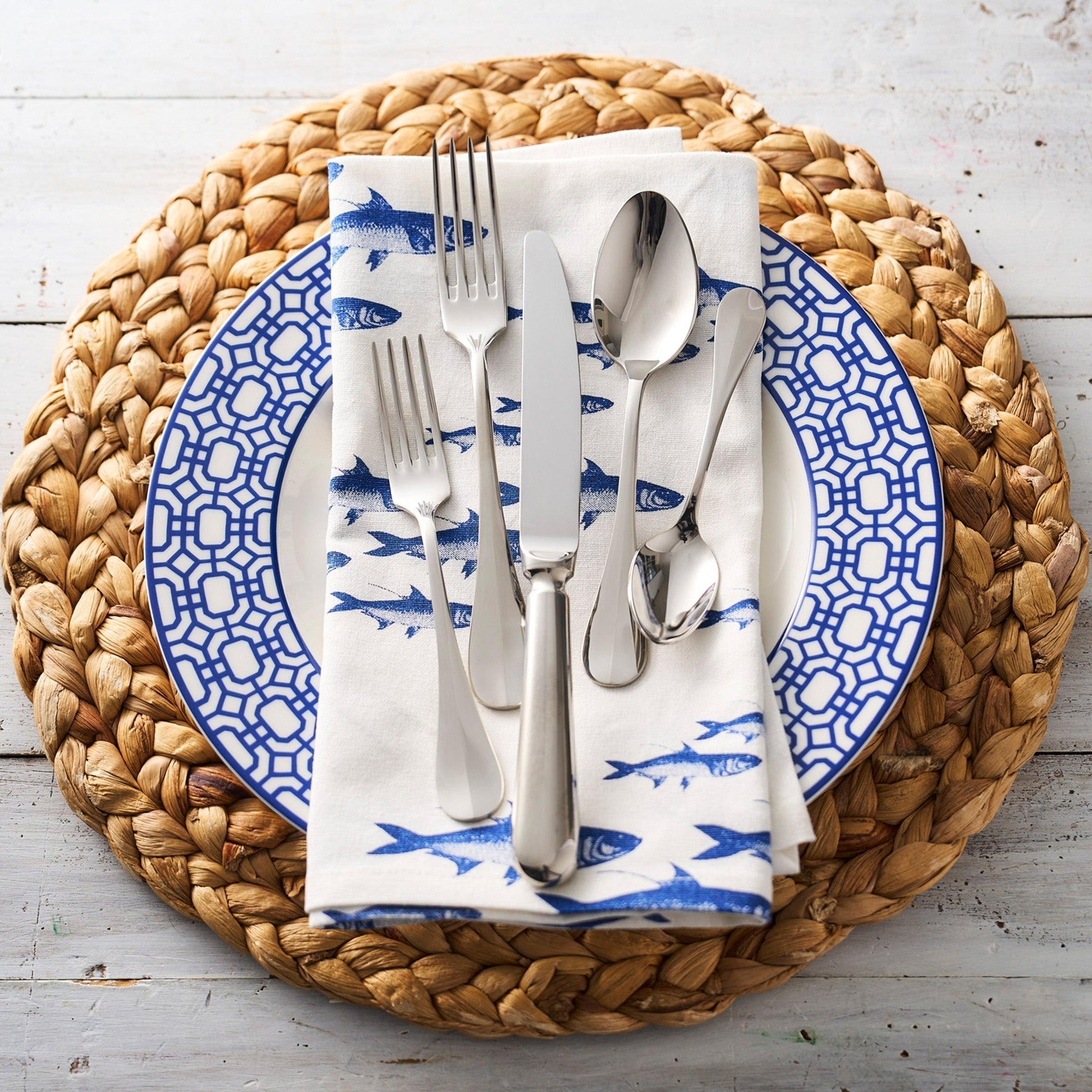 a blue and white plate topped with silverware