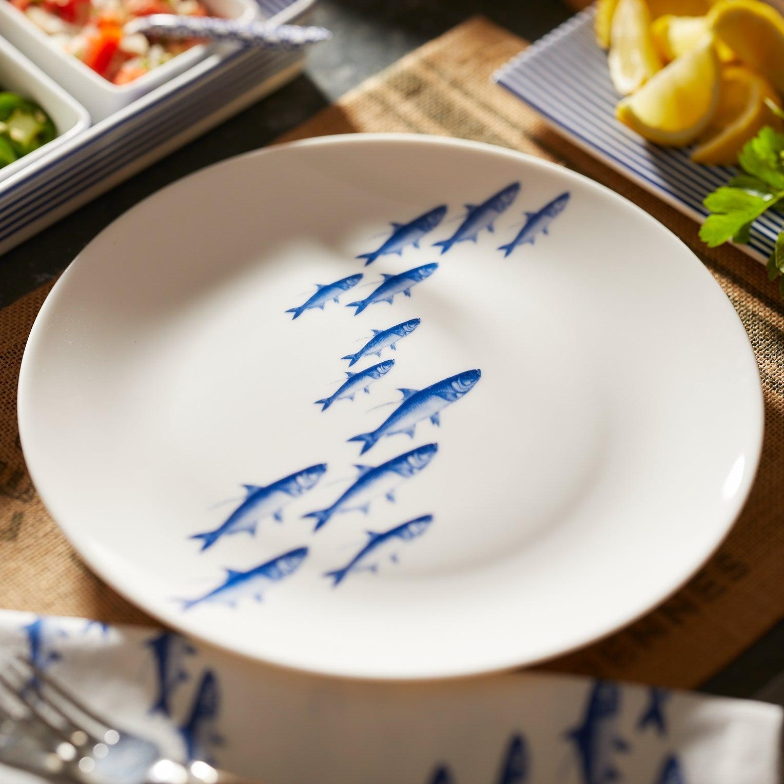 a white plate with blue fish drawn on it