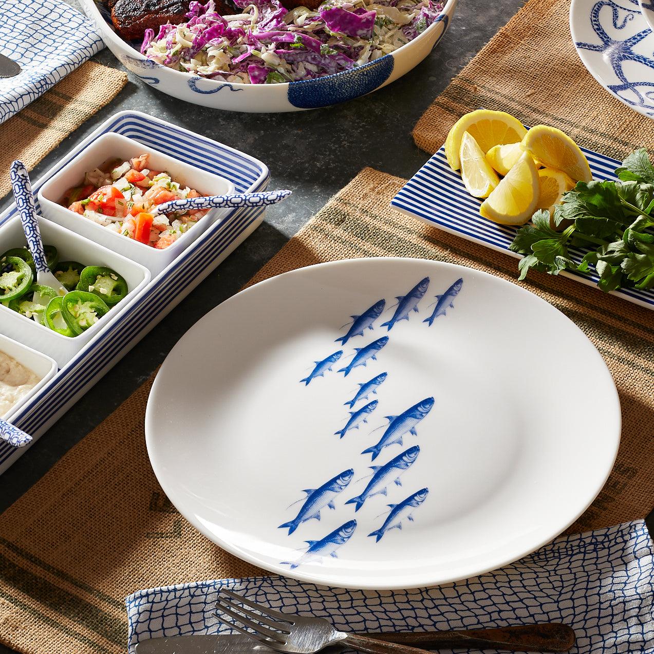 a white plate topped with a blue design next to a bowl of salad