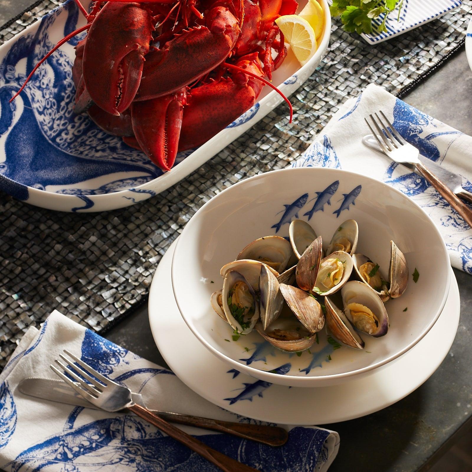 a bowl of clams and a plate of lobster on a table