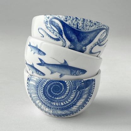 Lucy octopus snack bowl stacked above School of Fish and Shells blue-and-white bowls