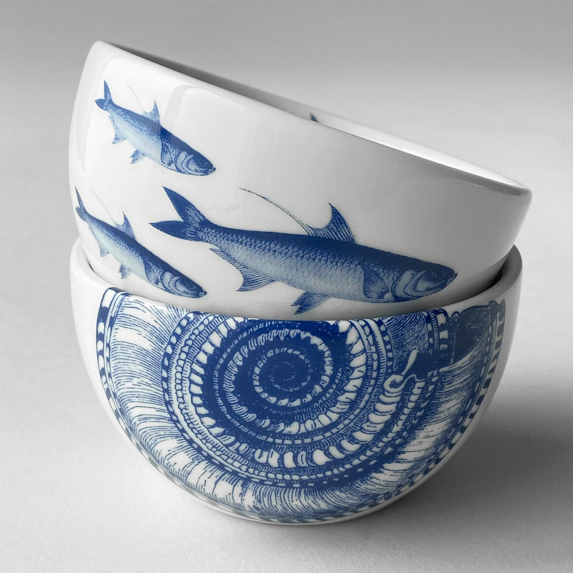 two blue and white bowls with fish on them