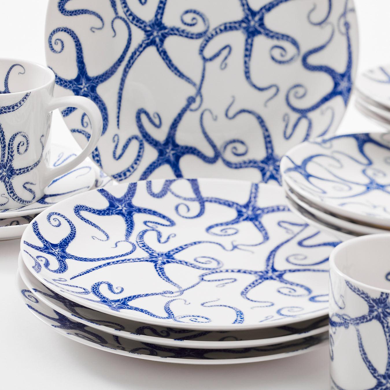 a blue and white plate and cups and saucers