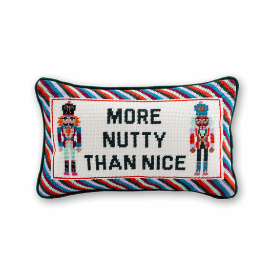 More Nutty Than Nice needlepoint pillow with two colorful nutcrackers, a diagonal striped border, and green piping
