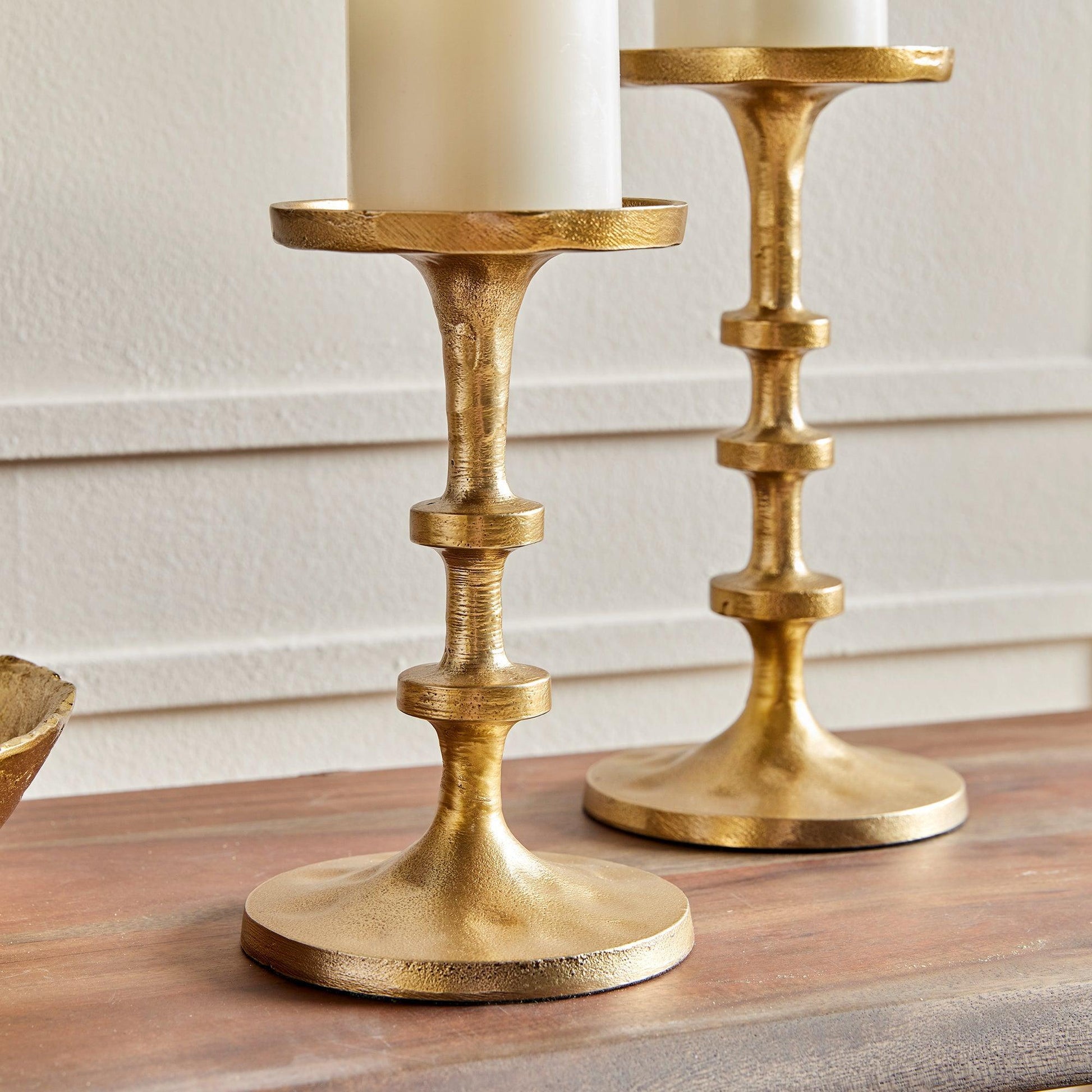 Close up of two gold candle stands with pillar candles