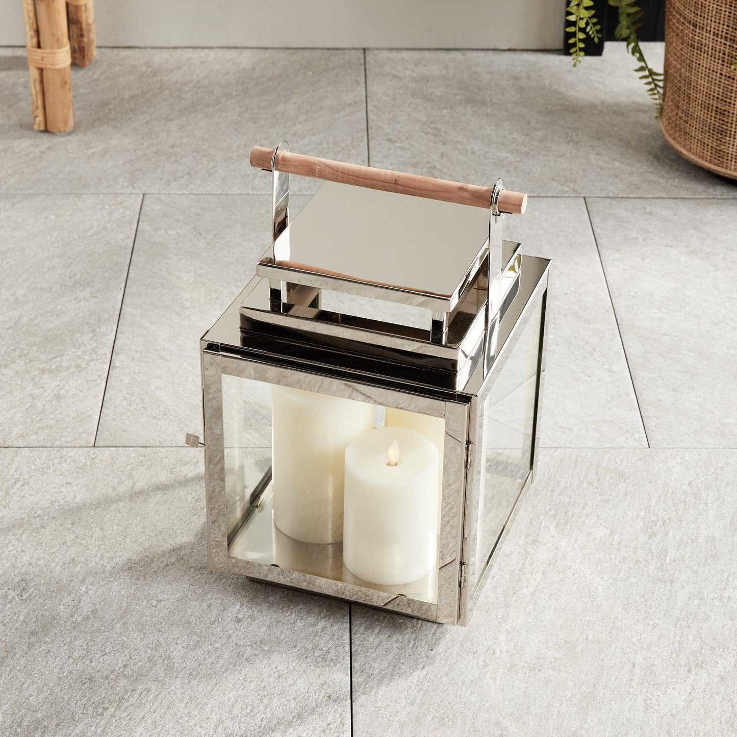 Silver lantern with wood handle on a stone floor