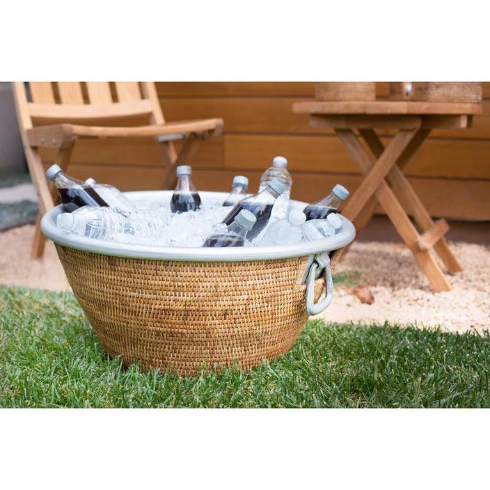 Rattan and aluminum tub with ice and drinks on grass 