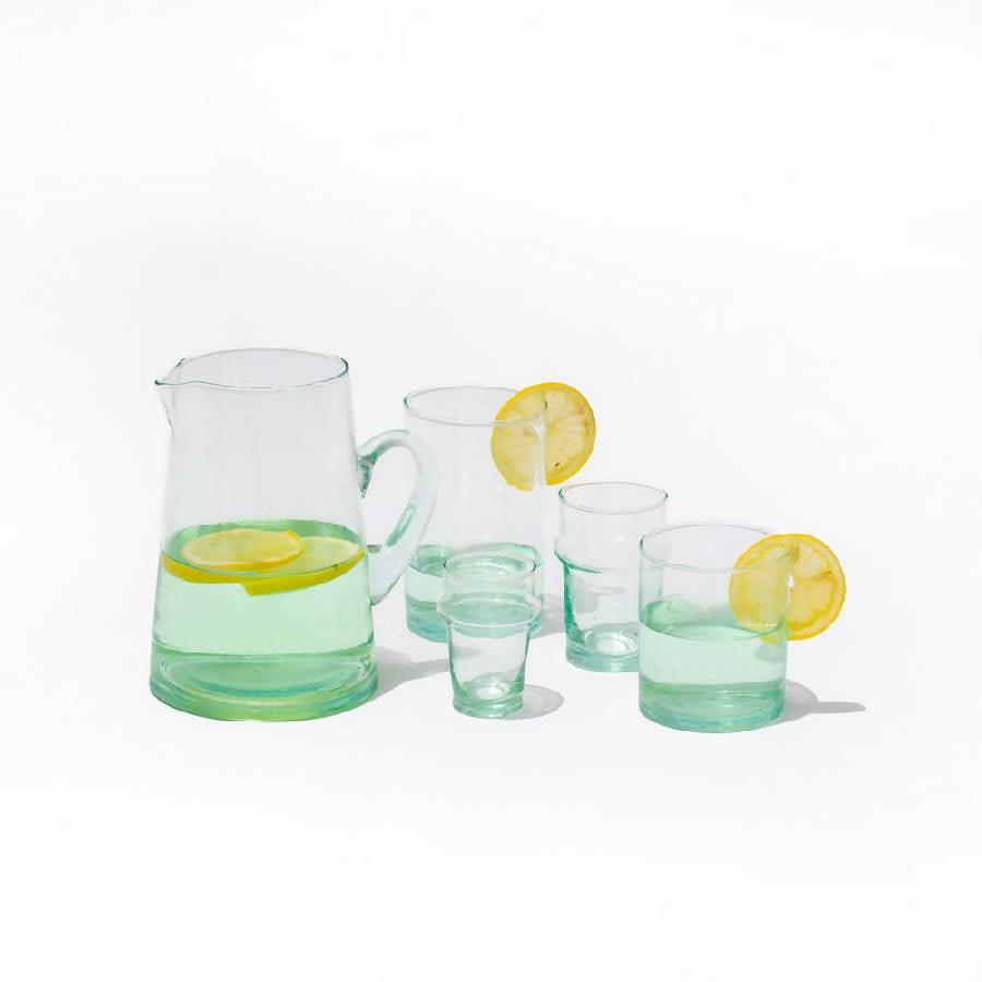 a pitcher and five glasses filled with lemonade