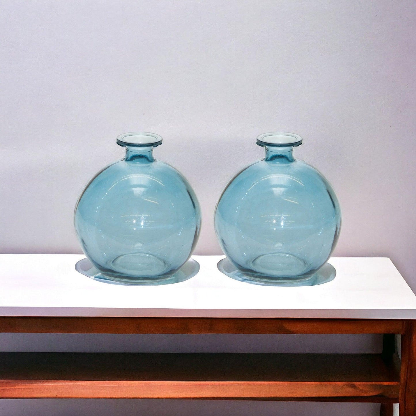 Two blue glass vases on a table 