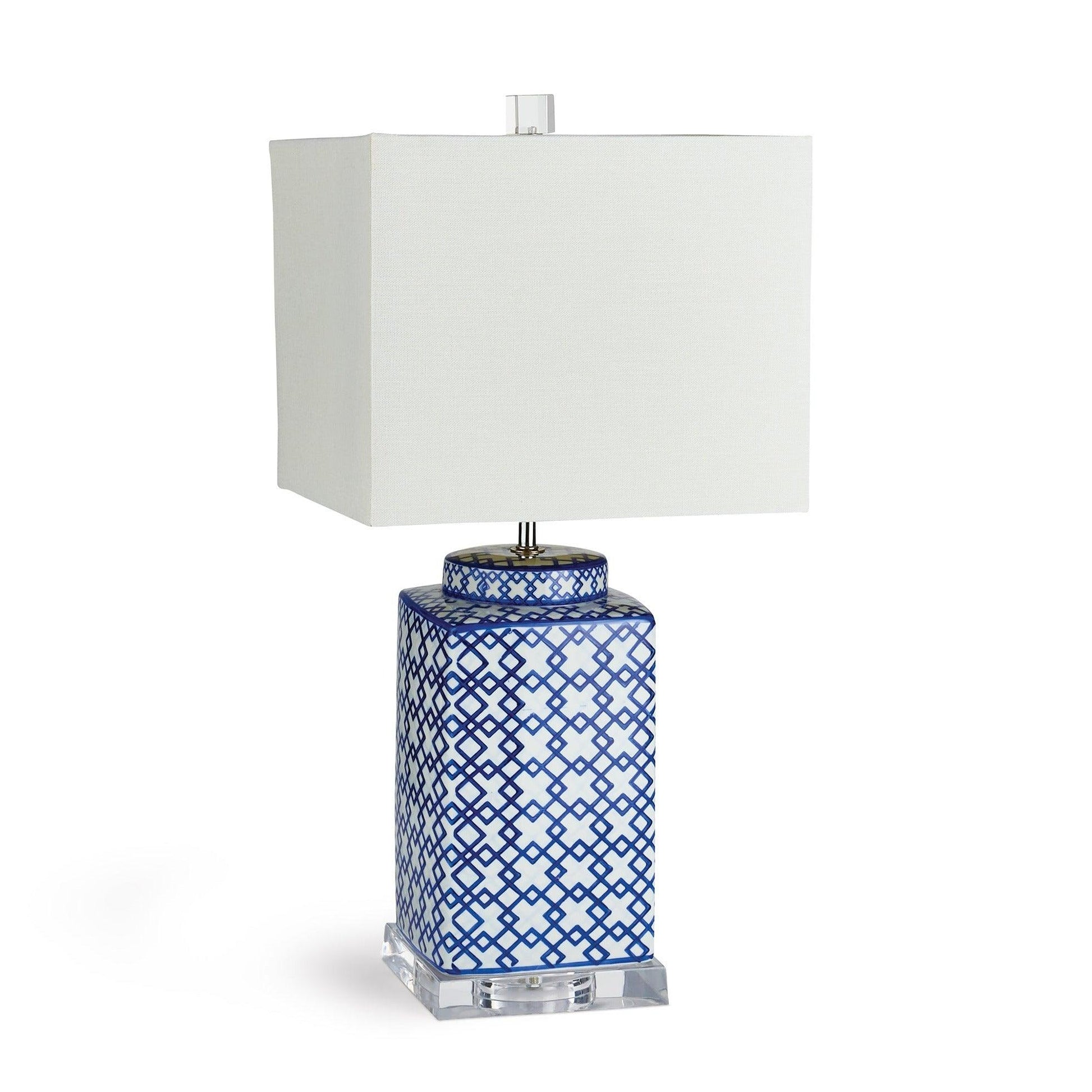 a blue and white table lamp with a white shade