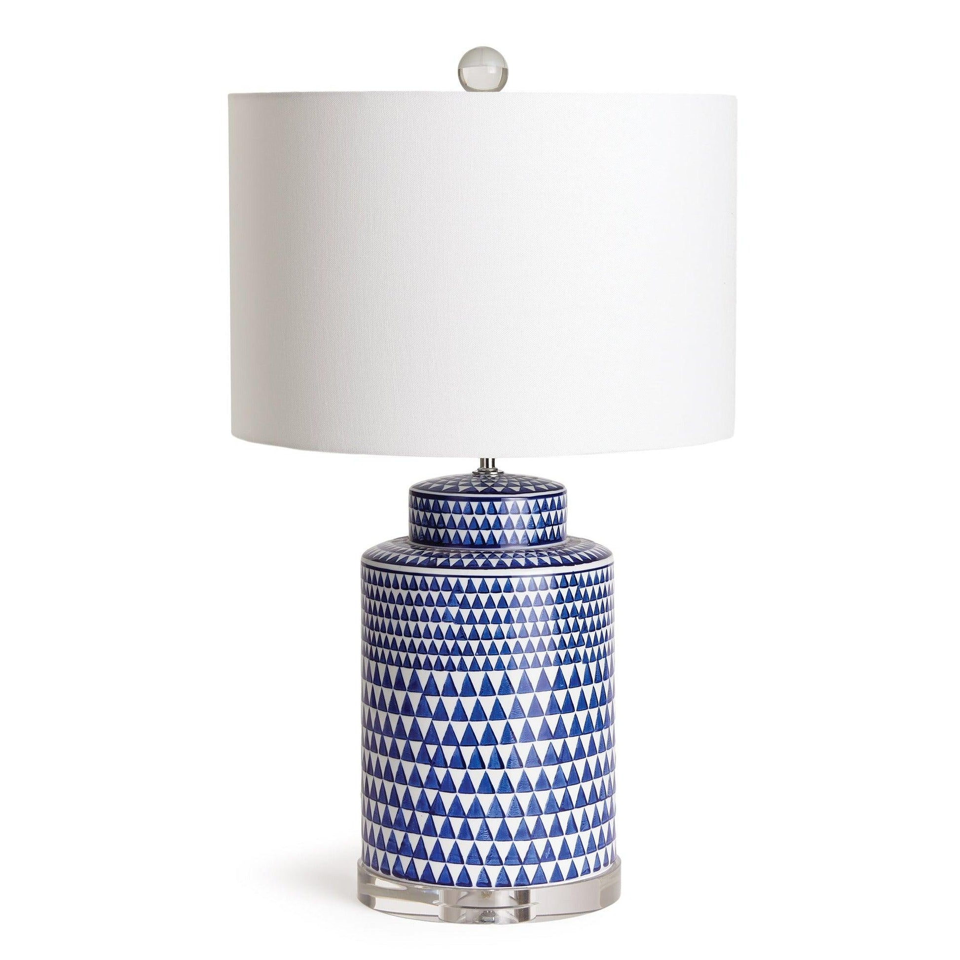 a blue and white table lamp with a white shade