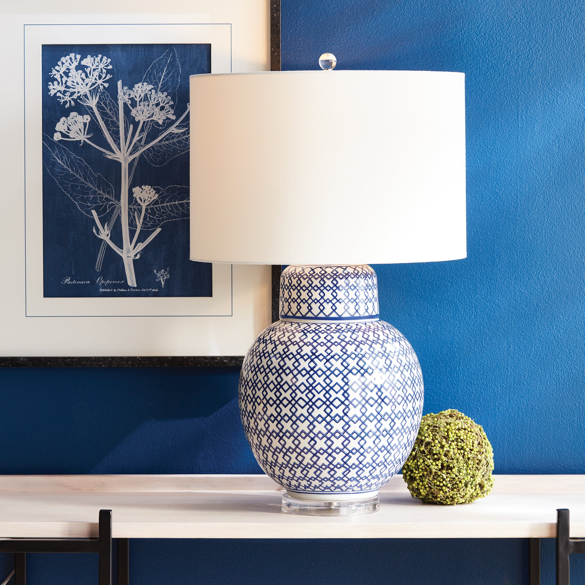 blue and white table lamp on table in front of a blue wall