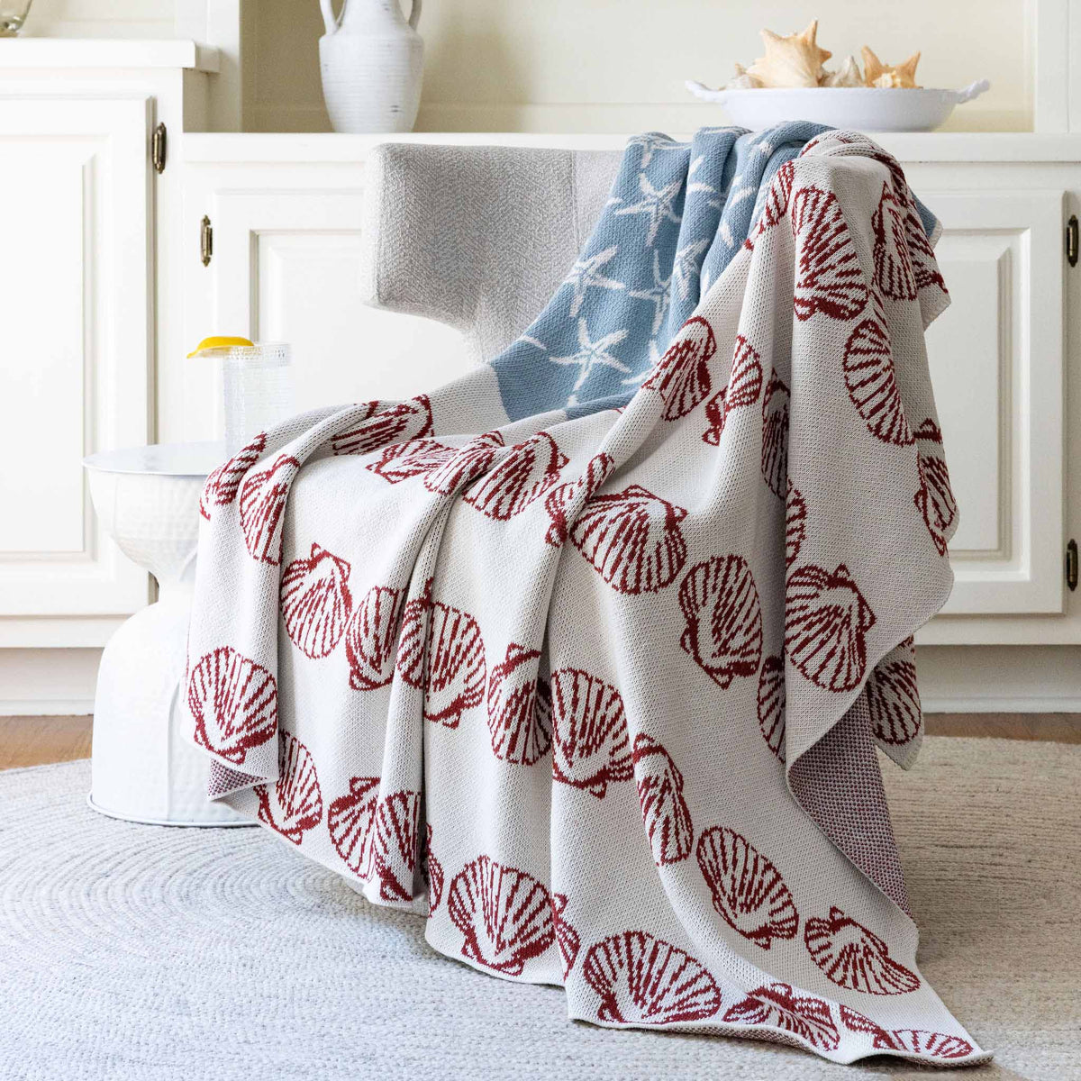	Coastal Flag throw draped over a light upholstered chair in a bright room