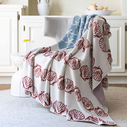 	Coastal Flag throw draped over a light upholstered chair in a bright room