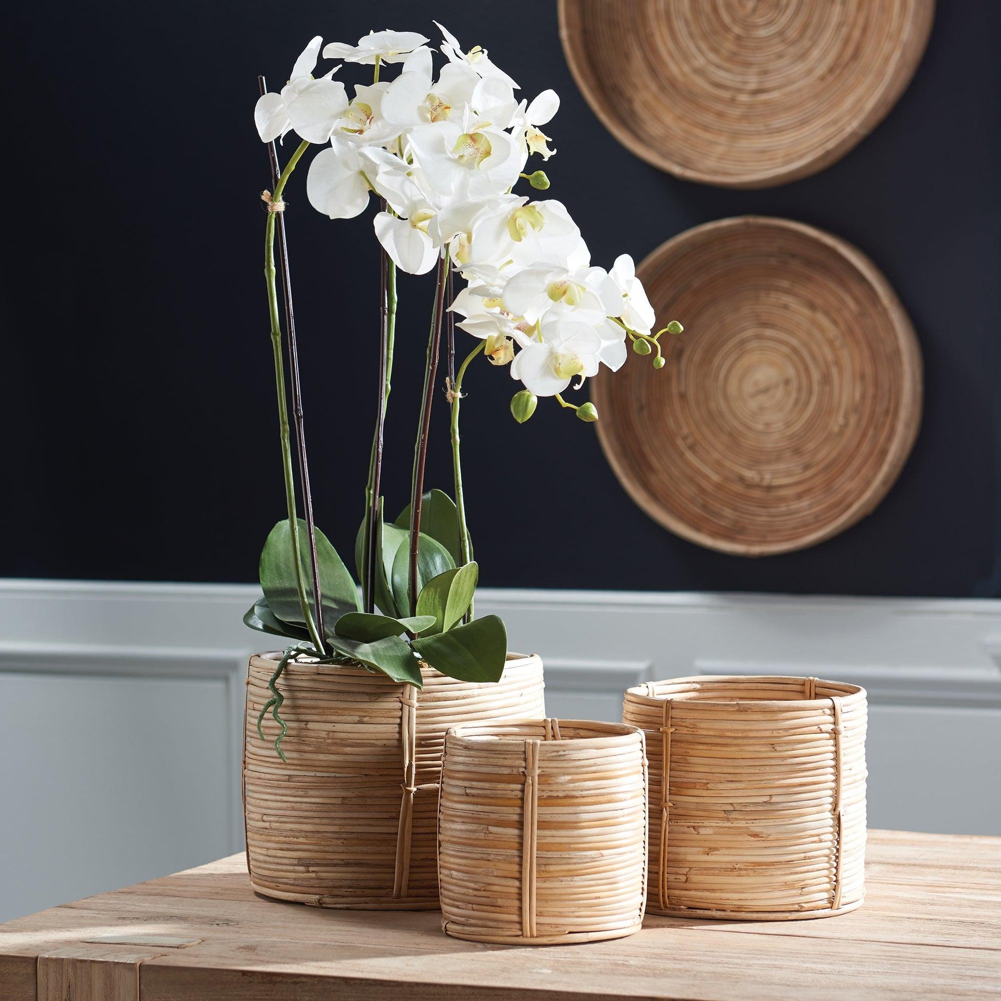 a wooden table topped with three vases filled with flowers