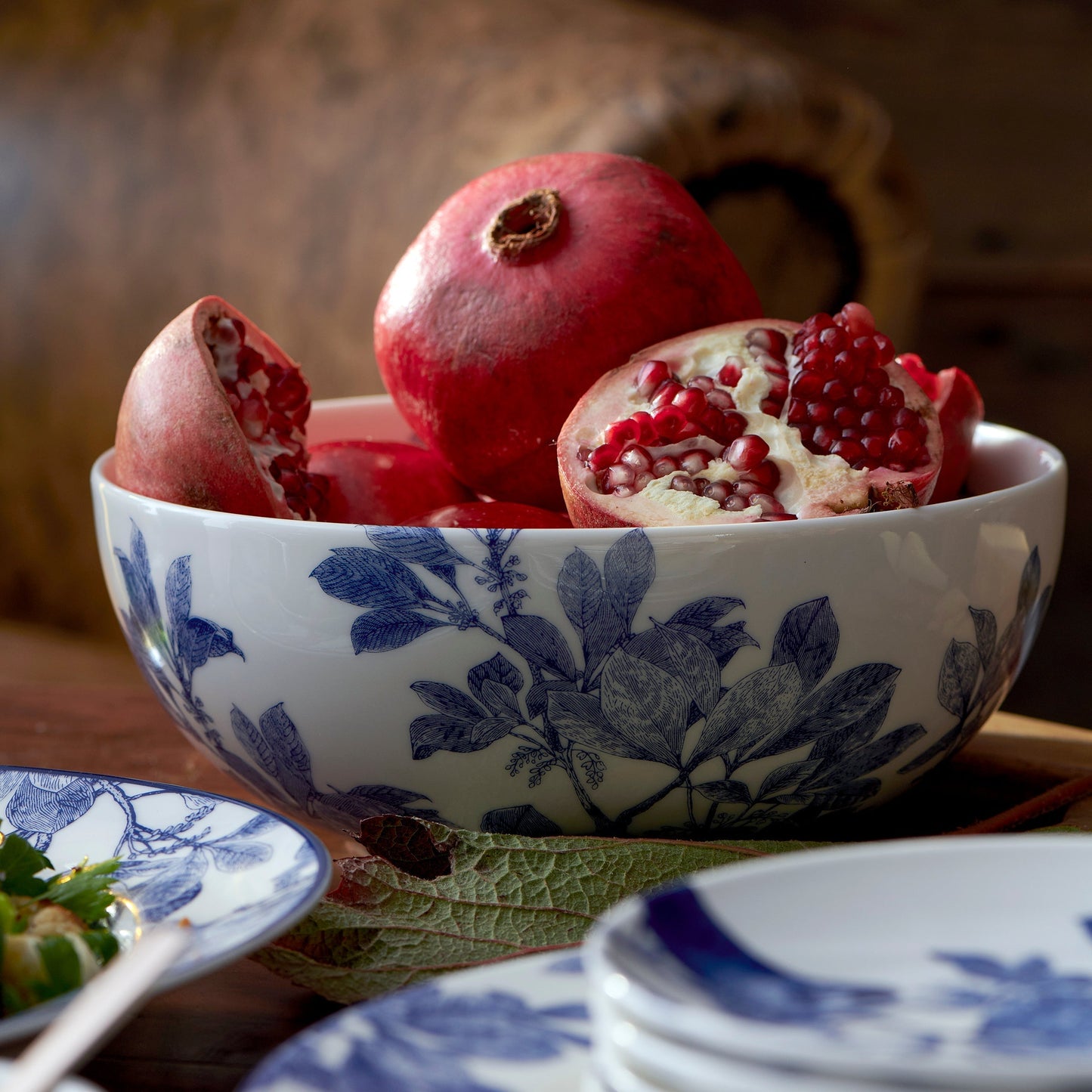 blue and white bowl filled with pomegranates