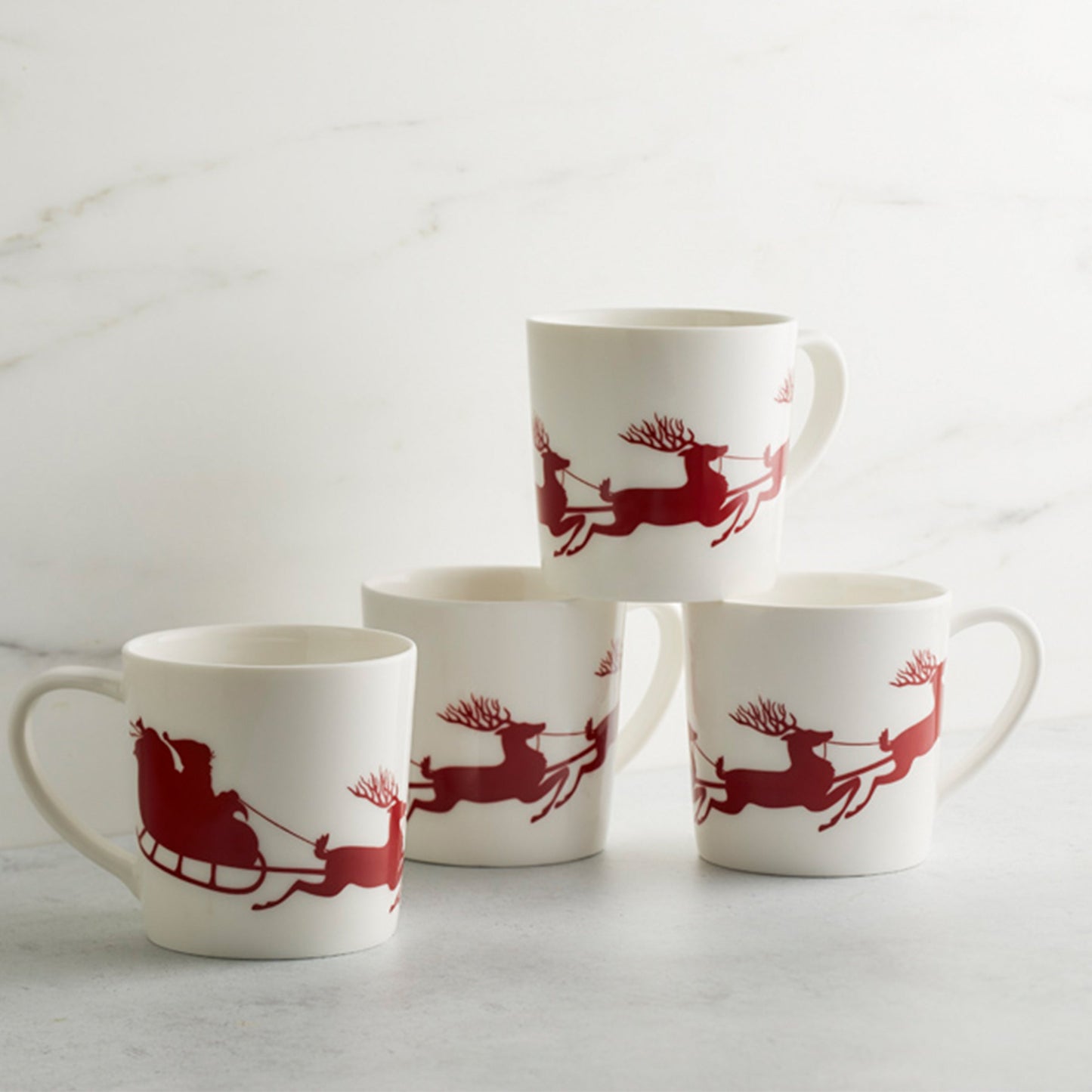 set of four white mugs with red santa sleigh and reindeer