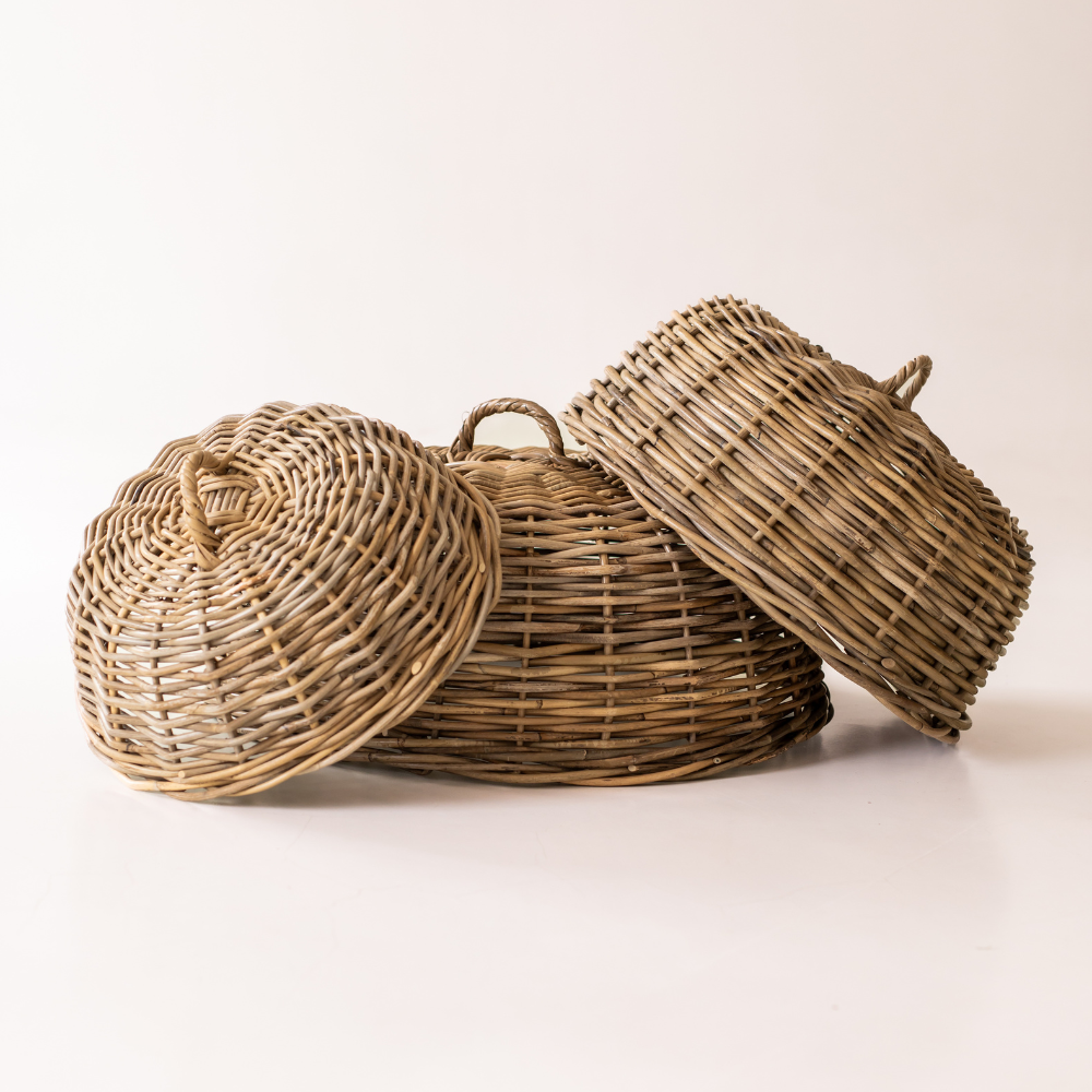 Three natural rattan dome food covers in graduated sizes with woven loop handles