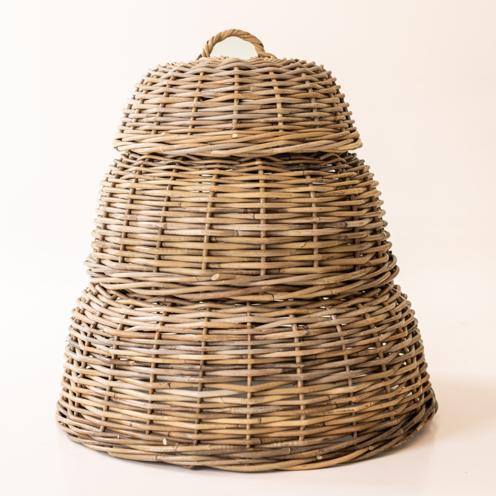 Three rattan cloche food covers stacked to show their graduated sizes