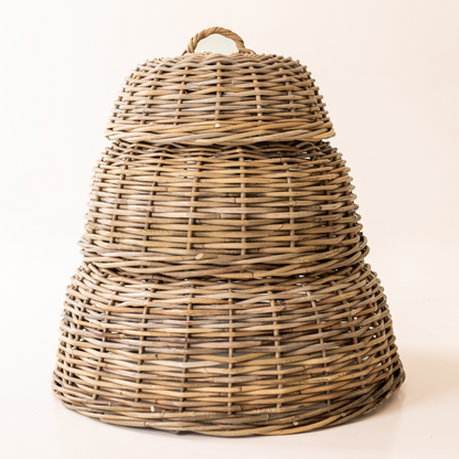 Three rattan cloche food covers stacked to show their graduated sizes