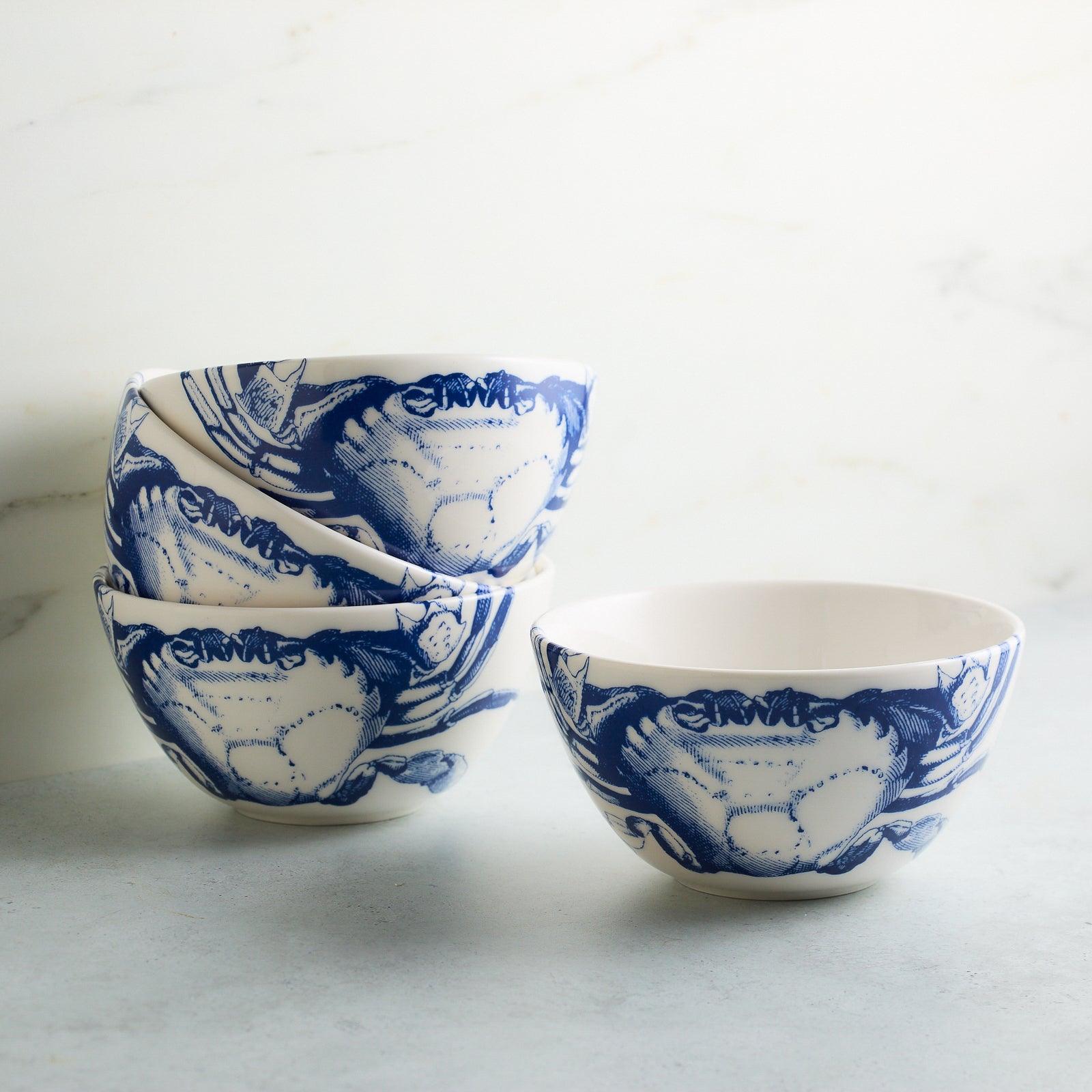 a set of four blue and white bowls sitting on top of a table