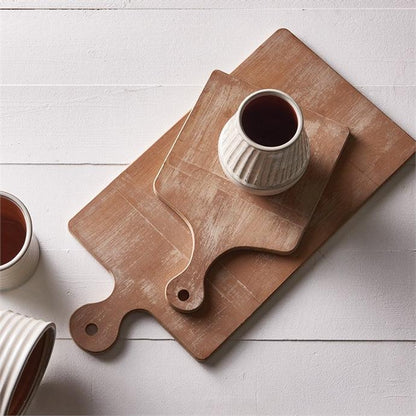 two wood cutting boards with a white cup