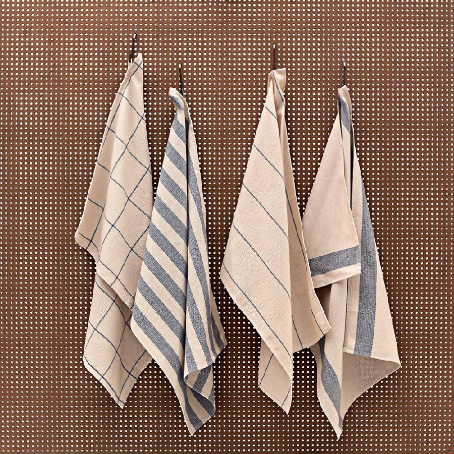 four towels hanging on a hook on a wall