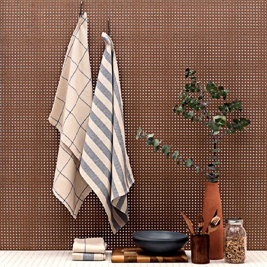 towels hanging on a rack next to a potted plant