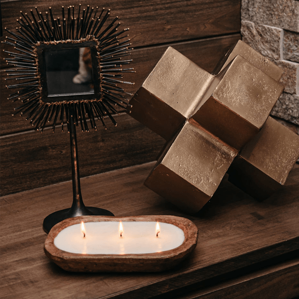 dough bowl candle on wood table with a mirror and decorative object