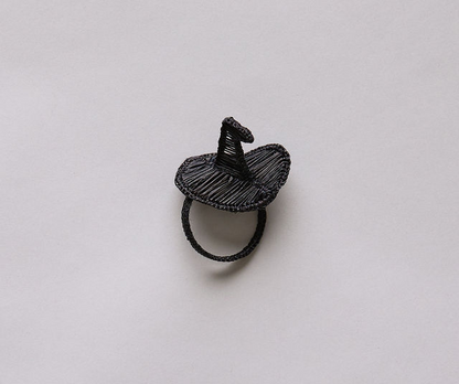 Black wire ring shaped like a witch's hat with a pointed top, resting on a light background.