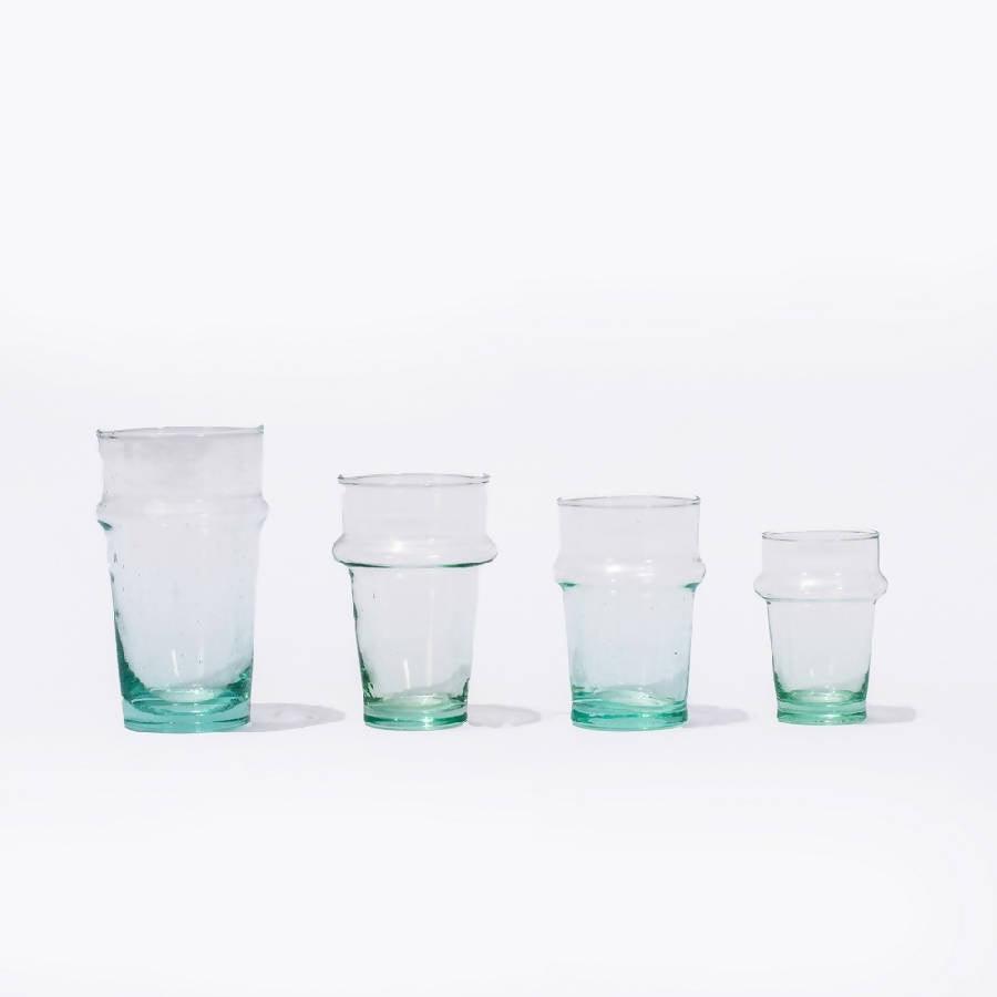 a set of four glasses sitting next to each other