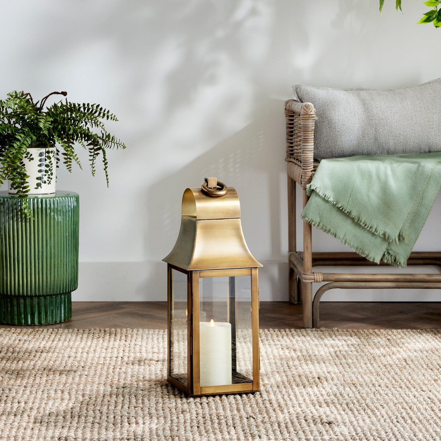 gold lantern on a rug with a couch in background