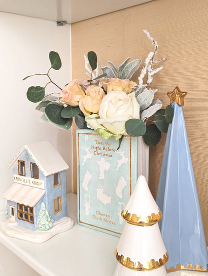 Serenity Blue folded Christmas tree styled with a white and gold tree, miniature house, and floral arrangement