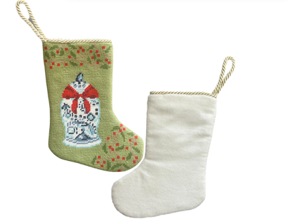 Front and back views of the ginger jar stocking showing its green needlepoint design, ivory velvet backing, and cord loop