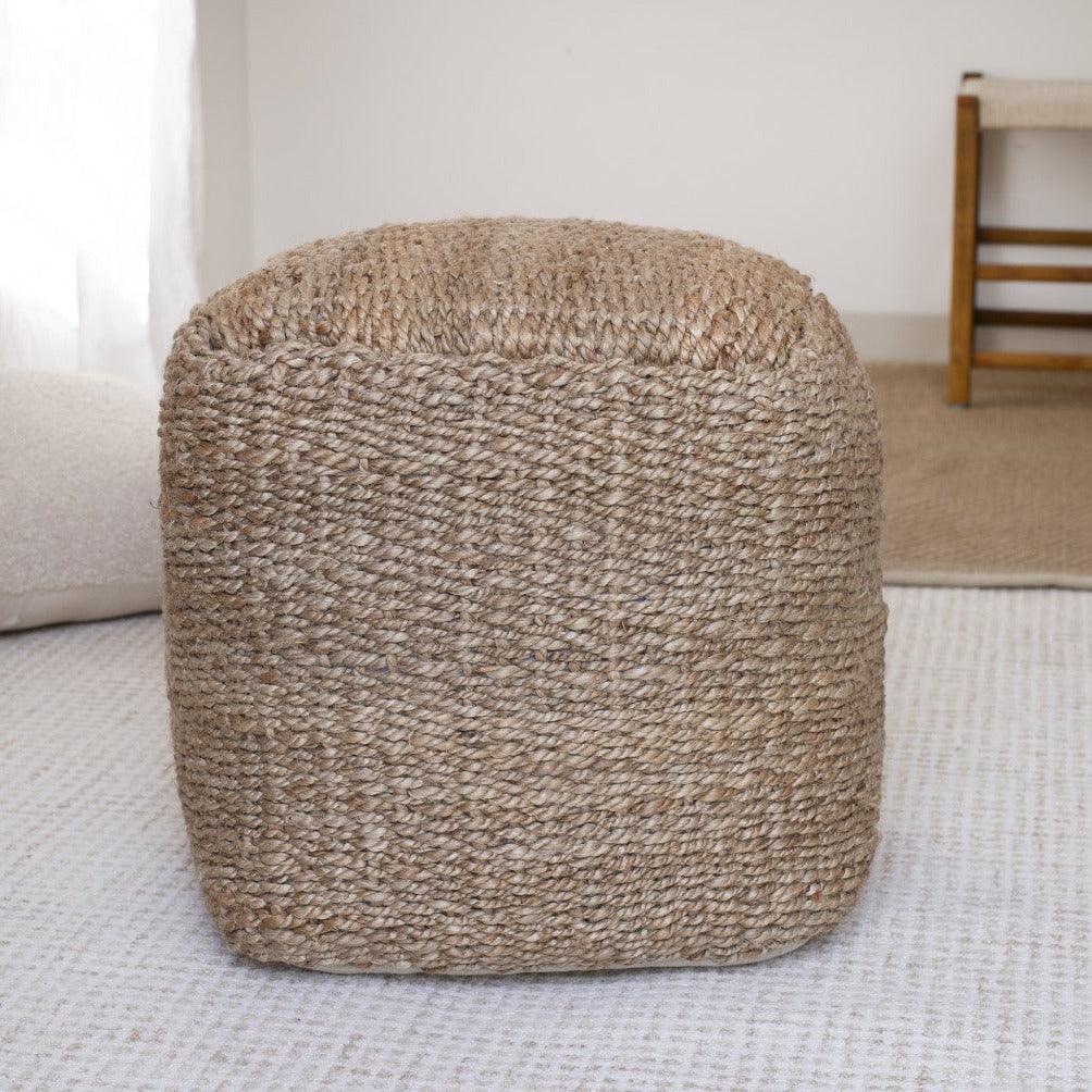 a large woven ottoman sitting on top of a rug