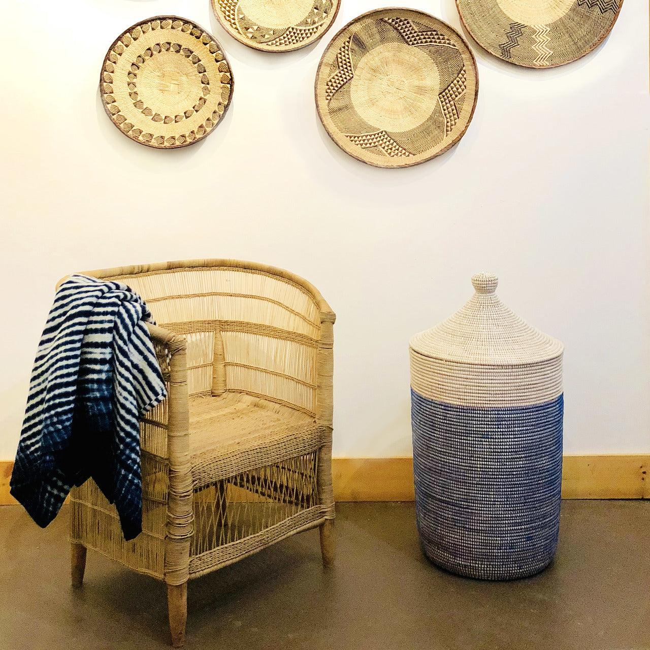 a wicker chair sitting next to a blue and white basket